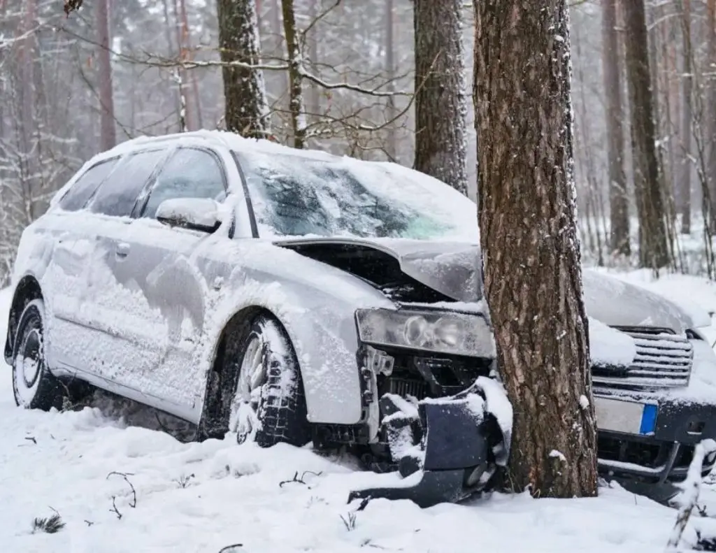 broken car crashes into tree after losing control on slippery road in snowy forest Cash For Used Cars